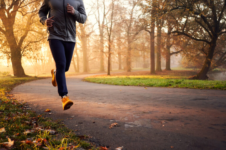 Close-up of male runner at autumn morning in park